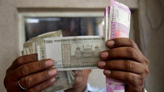 A cashier checks rupee notes inside a room at a fuel station in Ahmedabad in this file photo. Clocking its first loss in four sessions, the domestic unit finally settled 12 paise lower at 73.28 against the American currency.(Reuters Photo)
