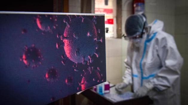 A health worker in PPE coveralls prepares to collect swab samples for coronavirus testing at Rajendra Nagar in New Delhi on Wednesday.