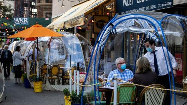 People sit outside Cafe Du Soliel under bubble tents following the outbreak of the coronavirus disease (Covid-19) in the Manhattan borough of New York City, US.(REUTERS) People sit outside Cafe Du Soliel under bubble tents following the outbreak of the coronavirus disease (Covid-19) in the Manhattan borough of New York City, US.(REUTERS)