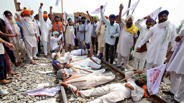 Farmers shout slogans as they block a railway track during a protest against farm bills passed by Parliament, in Devi Dasspura village on the outskirts of Amritsar in Punjab on September 24.(REUTERS) Farmers shout slogans as they block a railway track during a protest against farm bills passed by Parliament, in Devi Dasspura village on the outskirts of Amritsar in Punjab on September 24.(REUTERS)