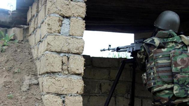 An Azeri serviceman aims his weapon at the frontline with the self-defence army of Nagorno-Karabakh in Azerbaijan.(Reuters)