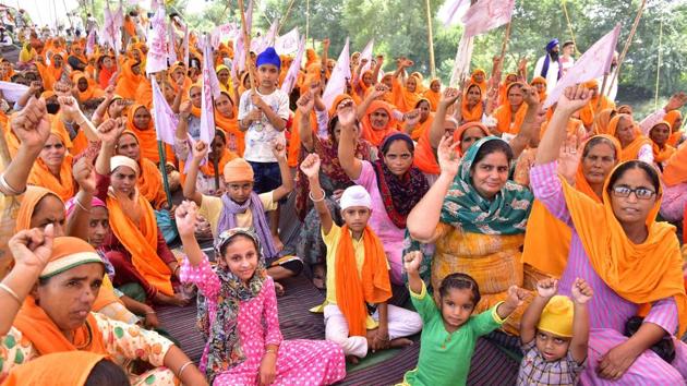Women and children raise slogans as they join protesting farmers during the 'Rail Roko' protest against the farm bills, at Devi Dasspura village, in Amritsar, Punjab. The President of India gave his assent to the three bills passed by Centre on Sunday making them an act.(Sameer Sehgal/Hindustan Times)