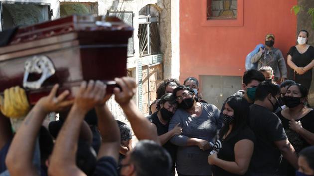 Relatives of Tranquilino Ruiz Cabrera, who died of Covid-19 are seen mourning during his burial at Asuncions’s Recoleta Cemetery, in Paraguay on September 22. (Jorge Saenz / AP)