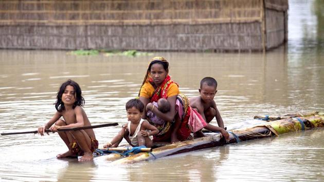 Flood affected people use rafts made of banana trunks to move to safer places at Mayong in Morigaon district of Assam.(PTI)