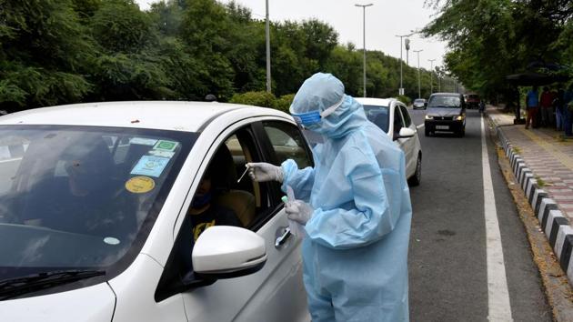 A healthcare worker takes a swab for RT-PCR based coronavirus testing at a paid drive through centre at Aruna Asaf Ali Marg, in New Delhi on Saturday.(Vipin Kumar/HT Photo) A healthcare worker takes a swab for RT-PCR based coronavirus testing at a paid drive through centre at Aruna Asaf Ali Marg, in New Delhi on Saturday.(Vipin Kumar/HT Photo)