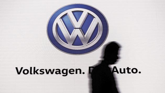 A man walks past a screen displaying a logo of Volkswagen at an event in New Delhi.(Reuters)