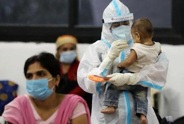 A medical worker in personal protective equipment (PPE) plays with a child of woman recovering inside a quarantine centre for the coronavirus disease (Covid-19) patients in New Delhi in this file photo.(Reuters Photo)