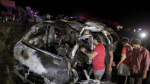 Rescue workers examine a burnt bus at the accident site on a highway outside of Karachi, Pakistan.(AP Photo) Rescue workers examine a burnt bus at the accident site on a highway outside of Karachi, Pakistan.(AP Photo)