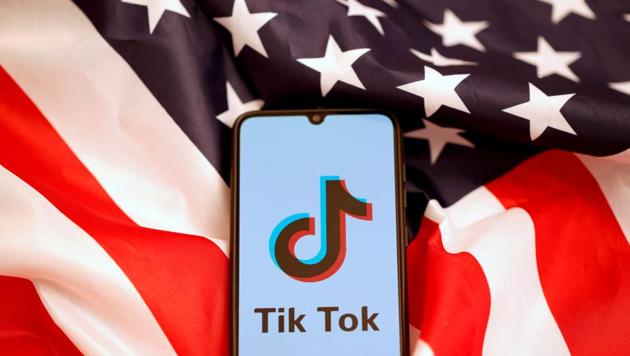 TikTok's logo is displayed on the smartphone while standing on the US flag.(REUTERS)