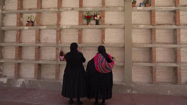 Relatives pray at the tomb of a Covid-19 victim at the General Cemetery in La Paz, Bolivia on September 23. The World Health Organization (WHO) has warned that the virus could claim another million before it is brought under control, a reminder of the unprecedented human toll exacted by a crisis that has shown little signs of relenting. (Juan Karita / AP)