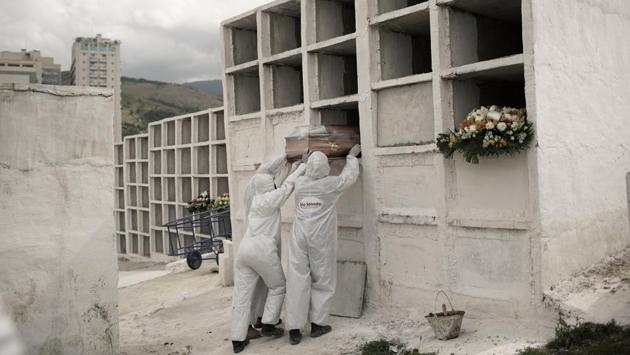 Cemetery workers place the coffin of Jose de Arimateia, 65, who died of Covid-19, into a niche at the municipal cemetery in Nova Iguacu, Brazil on September 24. Three countries – the United States, India and Brazil – have been the worst hit, recording more than 17 million infections between them, and together accounting for nearly 55% of all cases and over 44% of all deaths in the world. (Silvia Izquierdo / AP)