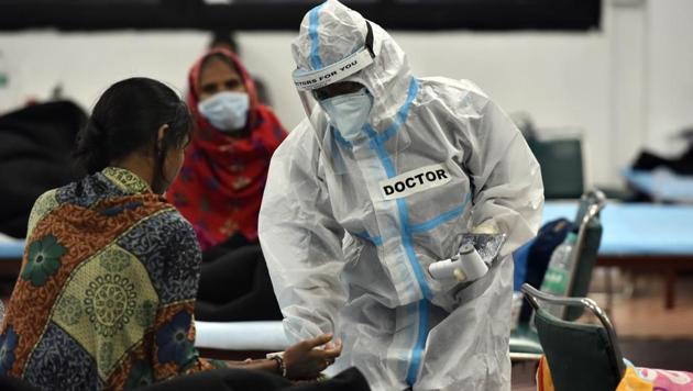 A health worker checks vitals of a Covid-19 patient inside the Commonwealth Games (CWG) Village Covid Care Centre, in New Delhi, India, on Sunday, September 27, 2020.(Sanjeev Verma/HT photo)