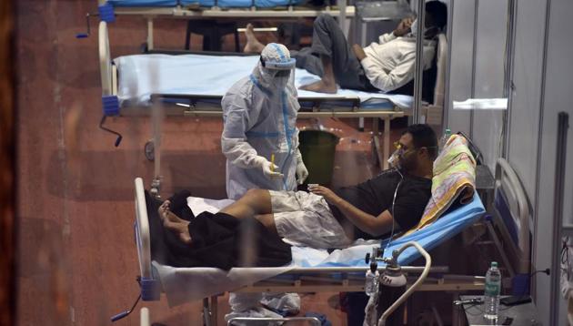 A health worker checks vitals of a Covid-19 patient inside the Commonwealth Games (CWG) Village Covid Care Centre, in New Delhi, India, on Sunday, September 27, 2020.(Sanjeev Verma/HT photo)