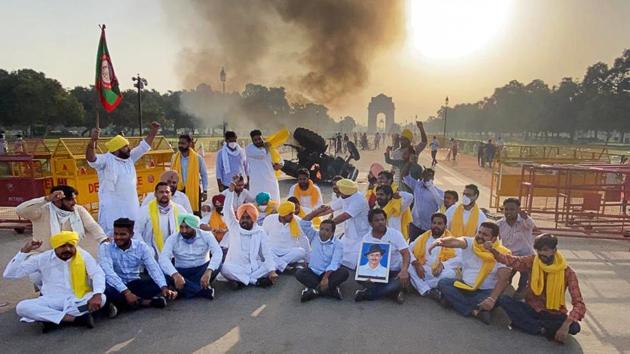 Punjab Youth Congress workers raise slogans near a tractor set aflame in protest against farm laws at India Gate in New Delhi on September 28. Three agriculture reforms that were tabled and passed in the Parliament’s monsoon session got President Ram Nath Kovind’s assent to be drafted as laws on September 27. (HT Photo)