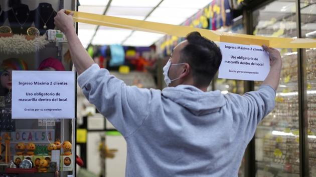 A trader puts up a tape to control the access to his store as a commercial area opens during the coronavirus (Covid-19) outbreak in Santiago, Chile on August 17, 2020.(Reuters Photo) A trader puts up a tape to control the access to his store as a commercial area opens during the coronavirus (Covid-19) outbreak in Santiago, Chile on August 17, 2020.(Reuters Photo)
