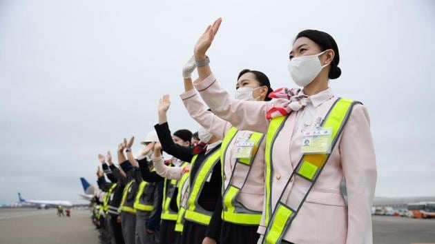Japan Airlines Co. (JAL) employees wearing protective masks wave to see off a Boeing 767-300ER aircraft at Narita Airport in Narita, Japan on Saturday.(Bloomberg File Photo) Japan Airlines Co. (JAL) employees wearing protective masks wave to see off a Boeing 767-300ER aircraft at Narita Airport in Narita, Japan on Saturday.(Bloomberg File Photo)