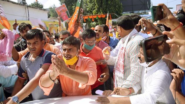 BJP ticket seekers and supporters gather around Bihar Deputy Chief Minister Sushil Kumar Modi's car, outside party office in Patna.(Santosh Kumar/HT PHOTO)