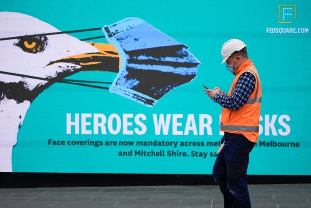 An essential worker wearing a face mask walks past a 'Heroes Wear Masks' sign in Melbourne after it became the first city in Australia to enforce mask-wearing in public as part of efforts to curb a resurgence of the coronavirus disease (Covid-19), July 23, 2020. REUTERS/Sandra Sanders/Files An essential worker wearing a face mask walks past a 'Heroes Wear Masks' sign in Melbourne after it became the first city in Australia to enforce mask-wearing in public as part of efforts to curb a resurgence of the coronavirus disease (Covid-19), July 23, 2020. REUTERS/Sandra Sanders/Files
