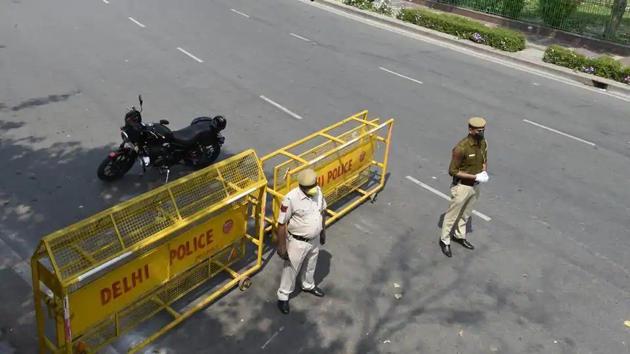 Police personnel man a barricade along a deserted stretch in Connaught Place in New Delhi.(Arvind Yadav/HT Photo)