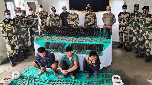 The three arrested men (sitting on the floor) along with the recovered arms and ammunition.(BSF) The three arrested men (sitting on the floor) along with the recovered arms and ammunition.(BSF)