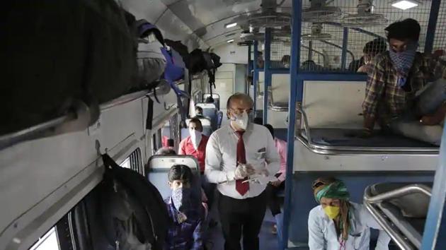 A ticket collector checks the tickets of migrant workers siting inside a special train to return to Agra in Uttar Pradesh state.(AP File Photo)