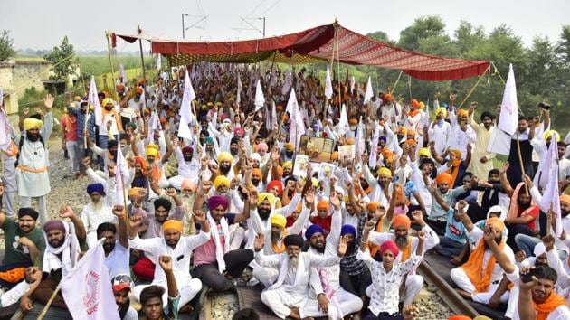 Farmers continue to sit on a 'Rail Roko' protest against the new agriculture bills at Amritsar-Delhi rail link in village Devi Dass Pura in Amritsar, Punjab on Monday.(Sameer Sehgal/HT Photo)