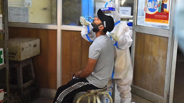 A health worker in PPE coveralls collects a swab sample from a person for coronavirus testing, at a government dispensary in New Delhi on Monday.(Raj K Raj/HT Photo) A health worker in PPE coveralls collects a swab sample from a person for coronavirus testing, at a government dispensary in New Delhi on Monday.(Raj K Raj/HT Photo)