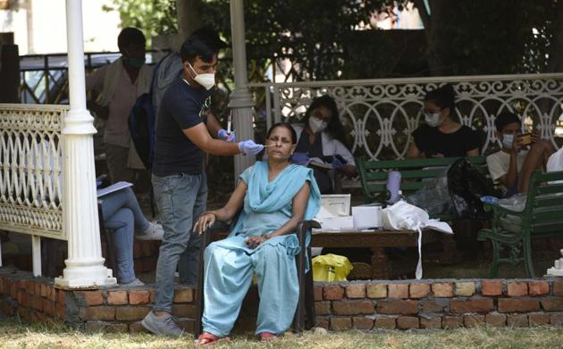 A health worker collects a swab sample from a woman for Covid testing on Monday.(Parveen Kumar/HT) A health worker collects a swab sample from a woman for Covid testing on Monday.(Parveen Kumar/HT)