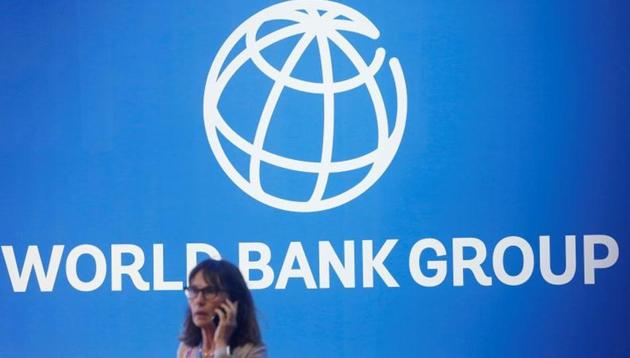 A woman standing near a logo of World Bank (REUTERS/Johannes P. Christo/File Photo)
