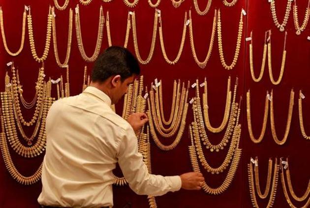 A salesman arranges gold ornaments on a display board inside a jewellery showroom in Kochi in this file phtoto.(Reuters Photo) A salesman arranges gold ornaments on a display board inside a jewellery showroom in Kochi in this file phtoto.(Reuters Photo)