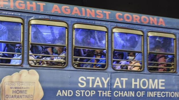 Commuters in Mumbai travel in a crowded bus which is carrying a message urging people to stay at home to fight the spread of Covid-19.(PTI)