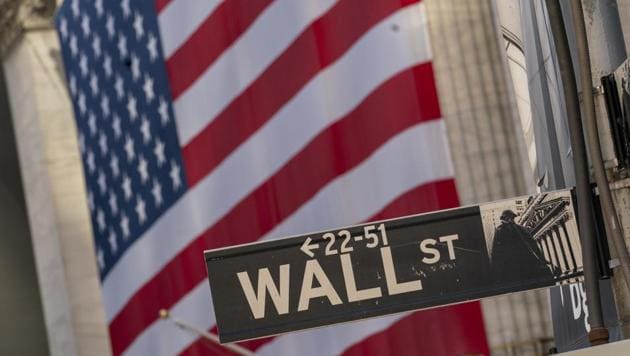 The Wall Street sign is framed by a giant American flag hanging on the New York Stock Exchange.(AP)