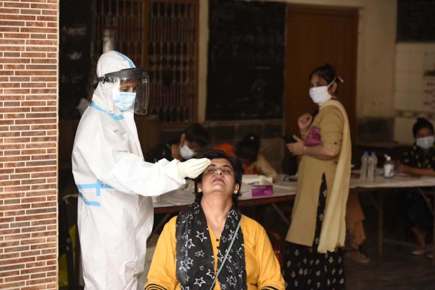 A health worker collecting a swab sample at Bhagwati Vidya Mandir School in Madanpuri, Gurugram, on Tuesday.(Parveen Kumar/HT)