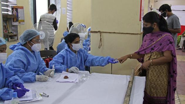 A health worker tests a person’s blood oxygen levels in Dhankawadi, Pune on September 27. The first countrywide sero survey, conducted between May 11 and June 4, showed overall infection prevalence to be 0.73%. All other parameters about the two surveys were similar except for the targeted age bracket — the second phase included those 10 years and above instead of those 18 and above previously. (Ravindra Joshi / HT Photo)