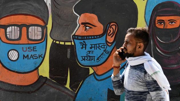 A man walks past a mural urging the use of face masks as precaution against the coronavirus in New Delhi on September 29. One in every 15 individuals, or 6.6% of people above the age of 10 years in India, have been exposed to Sars-Cov2, the virus that causes Covid-19, until August, according to the findings of Indian Council of Medical Research’s (ICMR) second national sero survey released on September 29. (Sajjad Hussain / AFP)