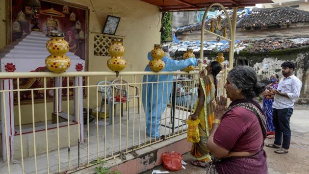 A woman (C) prays as a health worker (L) collects a sample from a woman (2L) for a Covid-19 test at a temple in Hyderabad on September 30. “It goes on to show that a large percentage of population is still susceptible to contracting the infection which is why it becomes really important to follow Covid-19 appropriate behaviour,” Dr VK Paul, member (health), Niti Aayog, told HT. (Noah Seelam / AFP)