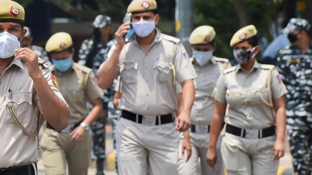 Police personnel wearing protective masks patrol a street in New Delhi.(PTI Photo)