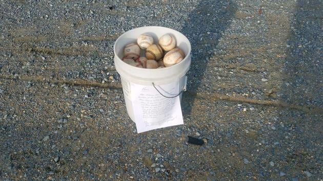 The images shows a bucket full of used baseballs with a note stuck to it. (Twitter/@TheBigE_21) The images shows a bucket full of used baseballs with a note stuck to it. (Twitter/@TheBigE_21)