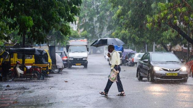 A man shields himself under umberlla at it rained in Kothrud in Pune. (Milind Saurkar/HT Photo) A man shields himself under umberlla at it rained in Kothrud in Pune. (Milind Saurkar/HT Photo)