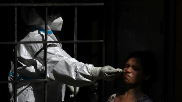 A healthcare worker wearing personal protective equipment (PPE) collects a swab sample from a woman, amid the spread of the coronavirus disease (COVID-19), in New Delhi. (REUTERS) A healthcare worker wearing personal protective equipment (PPE) collects a swab sample from a woman, amid the spread of the coronavirus disease (COVID-19), in New Delhi. (REUTERS)