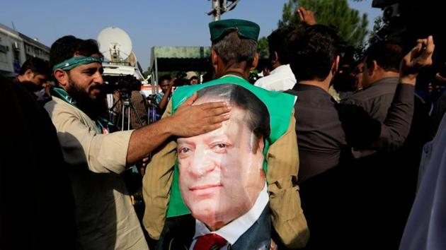 A supporter of former Pakistani prime minister Nawaz Sharif touches his picture during a demonstration.(Reuters) A supporter of former Pakistani prime minister Nawaz Sharif touches his picture during a demonstration.(Reuters)