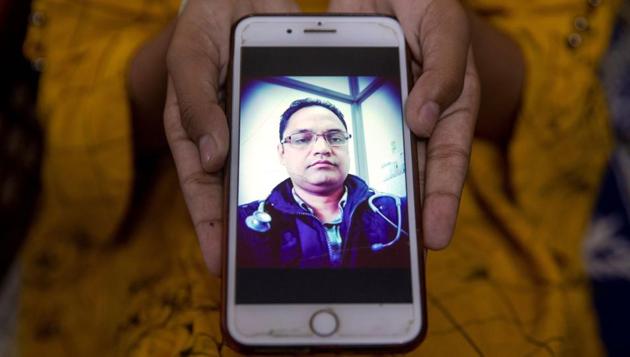 Aliza Ali, 12, shows a picture of her father Javed Ali, a government doctor, who died of Covid-19, in New Delhi on September 23. “He was taking all the precautions while continuously working on the frontline until he got symptoms. I and my children are proud of him. But we are struggling to cope with the present situation. Not a single day goes by when we don’t remember Javed and cry,” his wife Hena Kausar told Reuters. (Danish Siddiqui / REUTERS)