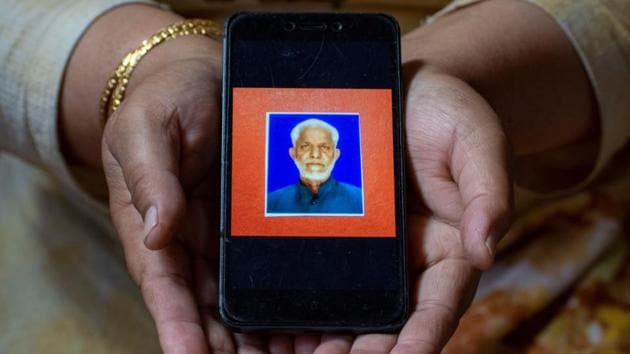 Humera Ulfat,42, a housewife, shows a picture of her father Mohammad Ashraf Baba, a shopkeeper, who died of Covid-19, in Srinagar on September 26. “It pains me whenever I recall my dad lying on a hospital bed helplessly. Doctors did not fulfil their duty the way that they’re supposed to. They never came close to my father to examine him. Eventually he died. My life won’t be like before, never,” Ulfat told Reuters. (Sanna Irshad Mattoo / REUTERS)