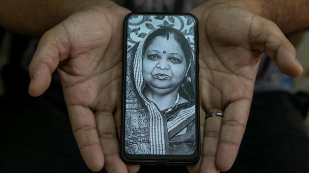 Tilak Raj,38, a software engineer, shows a picture of his mother Krishna Devi, a housewife, who died of Covid-19, in New Delhi on September 26. Raj says when his mother was hospitalised, there was no oxygen in the ambulance. When they arrived at the hospital, the cylinder that was provided was empty in five minutes. “If we had a better health system, my mother would have survived,” he told Reuters. (Adnan Abidi / REUTERS)