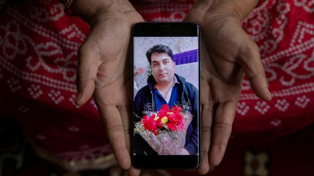 Abida Begum,55, a housewife, shows a picture of her son-in-law Luqman Ahmed, a factory worker, who died of Covid-19, in New Delhi on September 26. “My son-in law was a good husband, a good father. He is gone too early. A lack of medical facilities killed him. I appeal the government to ensure that they have good medical facilities in hospitals for the poor like us, so that people survive this pandemic,” Begum told Reuters. (Adnan Abidi / REUTERS)