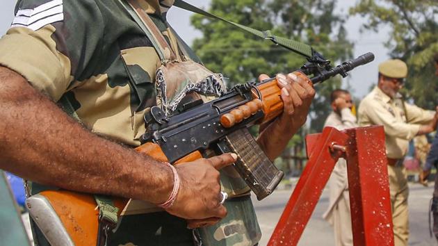A BSF jawan guards as Jammu and Kashmir Police personnel check the vehicles on the Jammu-Srinagar highway after a truck was seized with arms and ammunition, in Kathua.(PTI) A BSF jawan guards as Jammu and Kashmir Police personnel check the vehicles on the Jammu-Srinagar highway after a truck was seized with arms and ammunition, in Kathua.(PTI)
