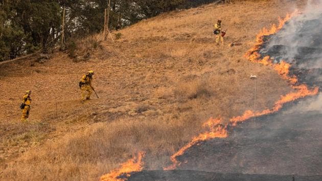Fire Fighters scrape a fire line with hand tools as the Glass Fire continues to burn in Napa Valley on September 29, 2020. The state officials deployed nearly 2,000 firefighters in the area by September 30 but reportedly only two percent of the fire has been contained so far. (Samuel Corum / AFP)