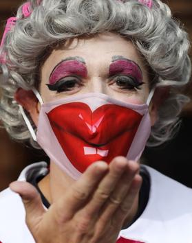 An actor dressed as a pantomime dame poses for photographers as they march on Parliament to demand more support for the theatre sector amid the COVID-19 pandemic in London, Wednesday, Sept. 30, 2020. (AP)