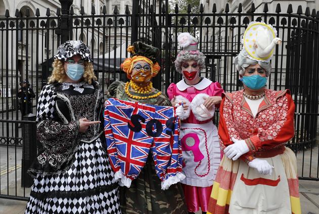 Actors dressed as pantomime dames stop at the entrance of Downing Street as they march on Parliament to demand more support for the theatre sector amid the COVID-19 pandemic in London, Wednesday, Sept. 30, 2020. (AP)