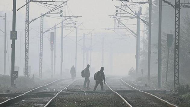 People walk on a railway track amid dense fog/smog, at Hazrat Nizamuddin Railway station in New Delhi. (Biplov Bhuyan/ Hindustan Times Archives) People walk on a railway track amid dense fog/smog, at Hazrat Nizamuddin Railway station in New Delhi. (Biplov Bhuyan/ Hindustan Times Archives)